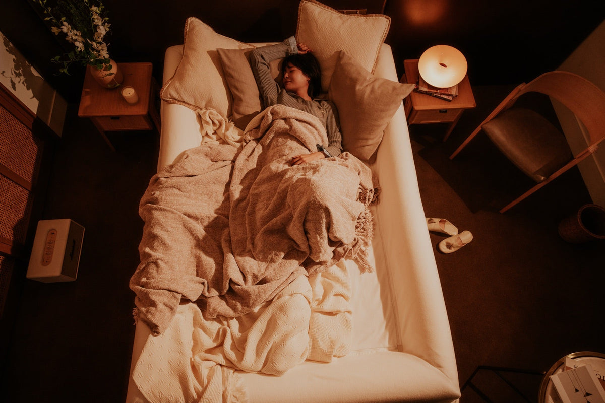 Bednest 巣作りベッドクッションの中で毛布にくるまって眠る女性（夜・真上から）